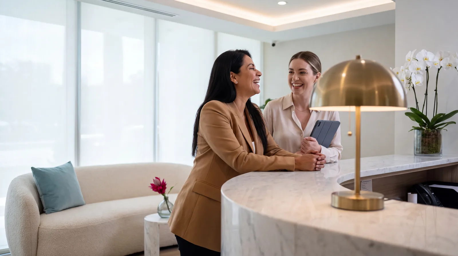 Woman chatting with a coordinator at the reception desk of an aesthetic clinic