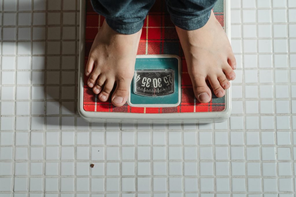 Person standing on scale weighing themselves