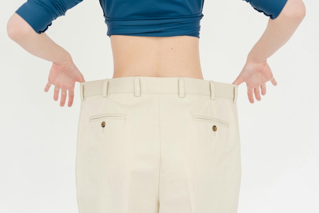 Person holding pants from weight loss