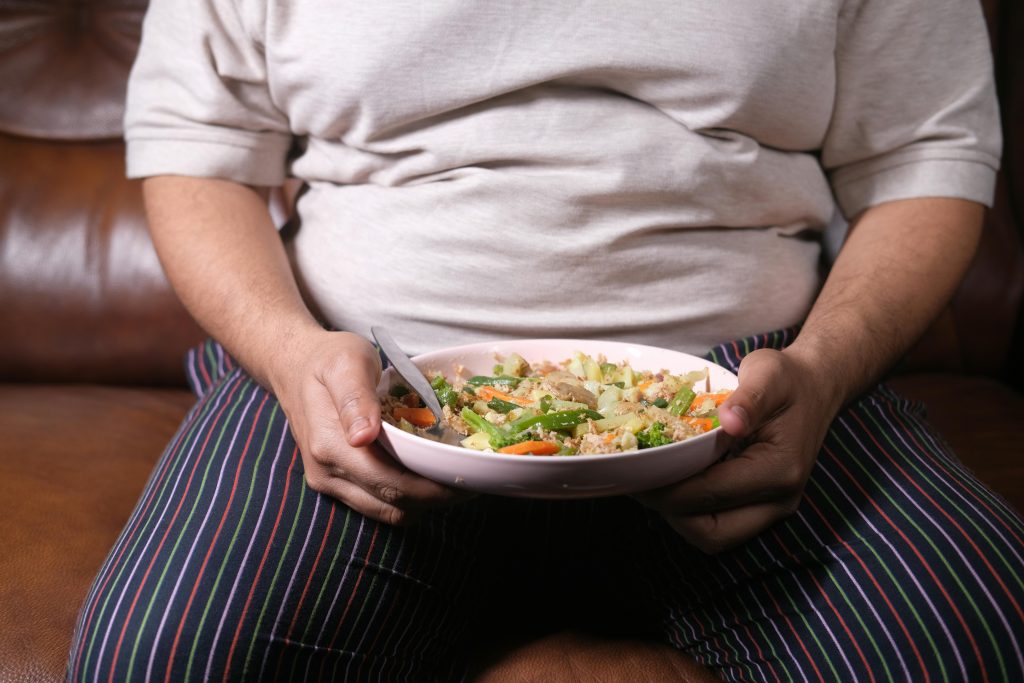 Overweight person holding a plate of food
