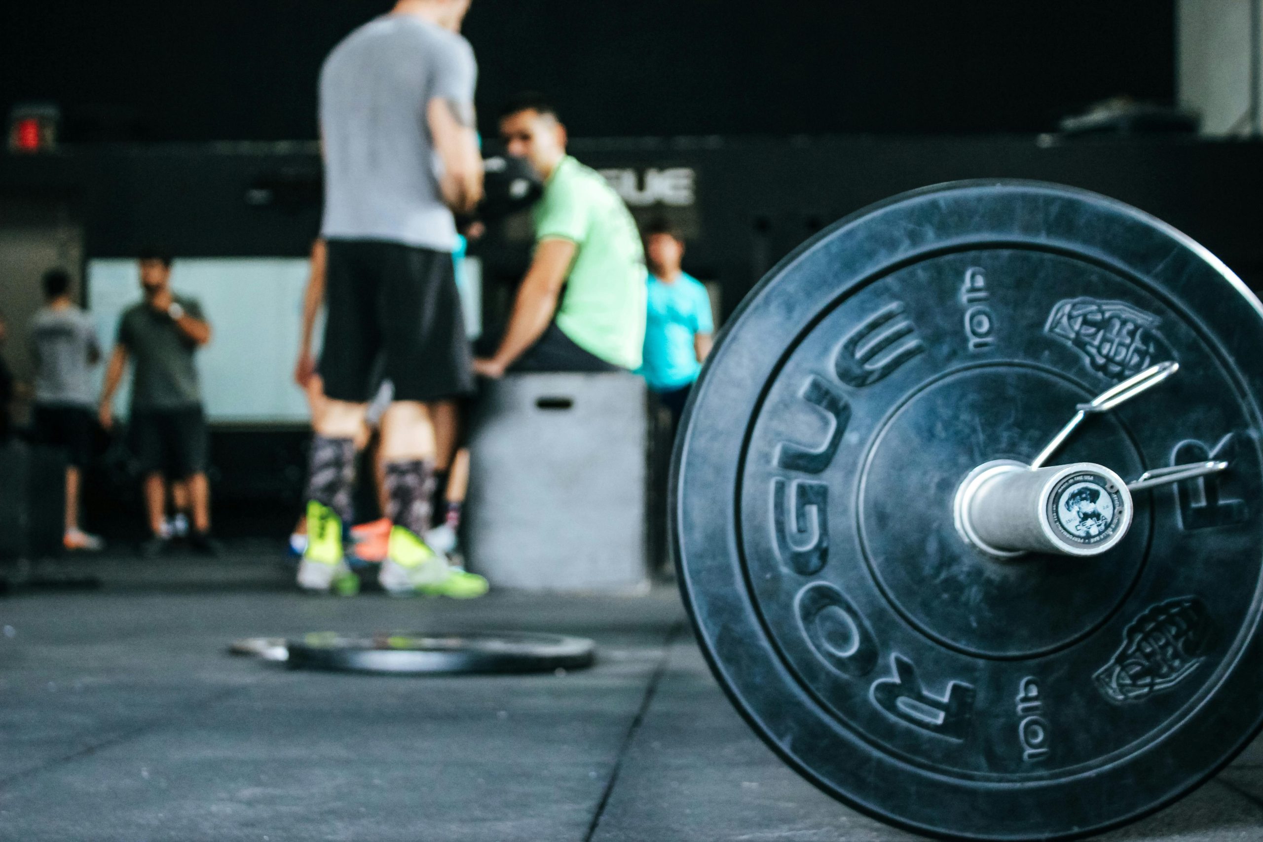 Close-up of a weight in a gym with people standing in the background